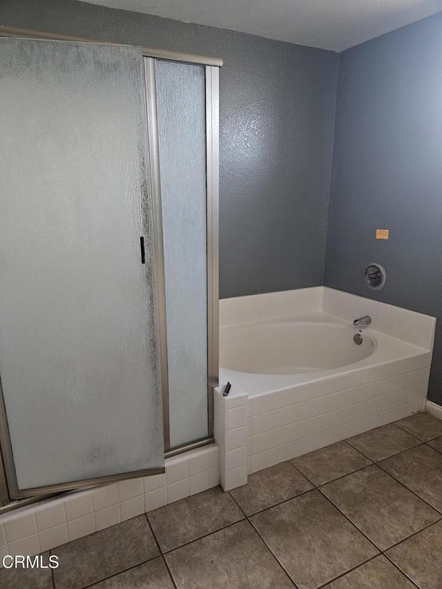 bathroom featuring tile patterned flooring and shower with separate bathtub