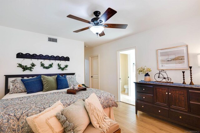 bedroom with ensuite bathroom, ceiling fan, and light wood-type flooring