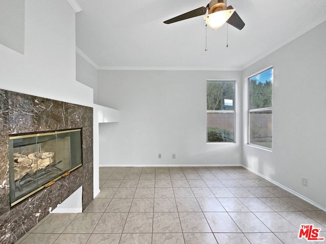 unfurnished living room with a tile fireplace, light tile patterned floors, ceiling fan, and ornamental molding