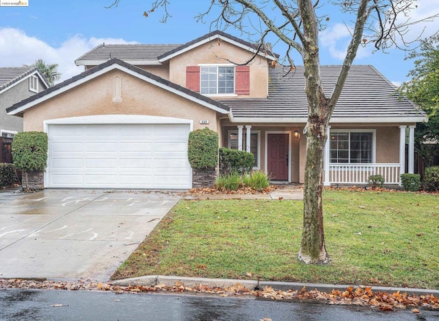 front of property featuring a garage, a front yard, and covered porch