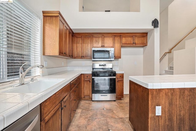 kitchen featuring sink, stainless steel appliances, and tile countertops