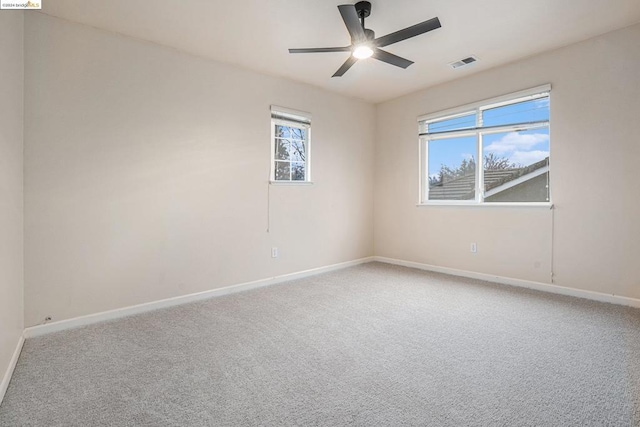 spare room with ceiling fan and carpet