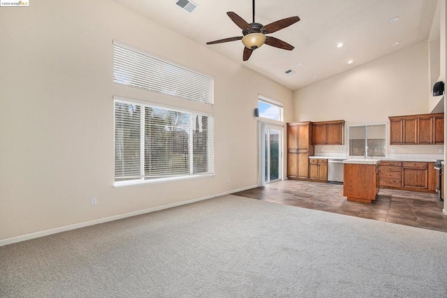 kitchen featuring a kitchen island, carpet, a towering ceiling, and stainless steel dishwasher