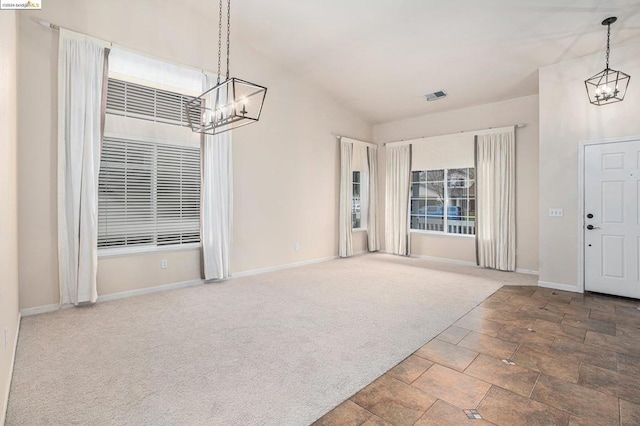 carpeted foyer entrance with vaulted ceiling