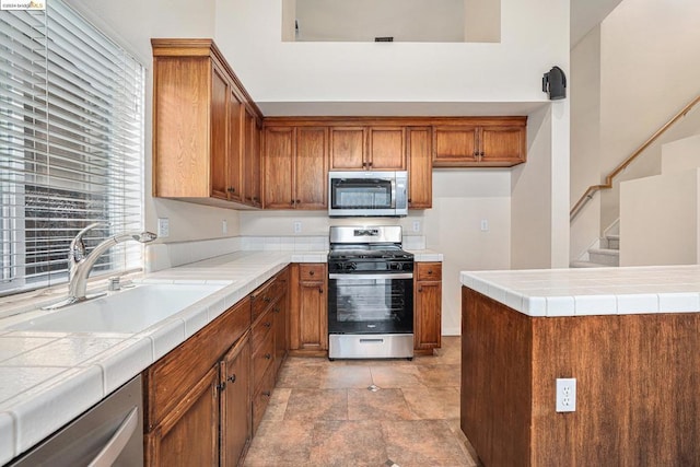 kitchen featuring sink, tile counters, and appliances with stainless steel finishes