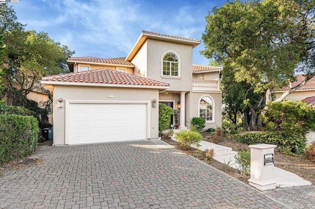 mediterranean / spanish-style home with a garage and a balcony