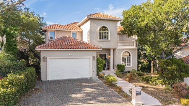 mediterranean / spanish-style house featuring a balcony and a garage