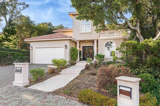 mediterranean / spanish home with a garage and a balcony