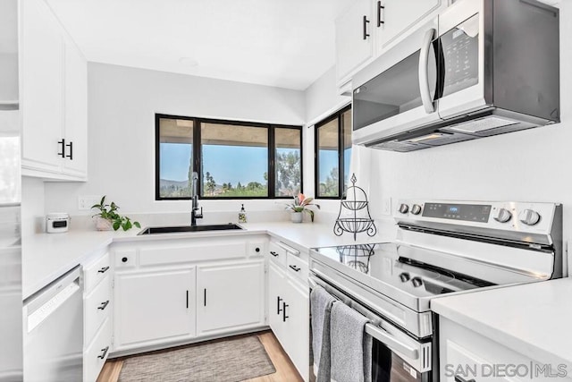 kitchen featuring light hardwood / wood-style flooring, stainless steel appliances, white cabinetry, and sink