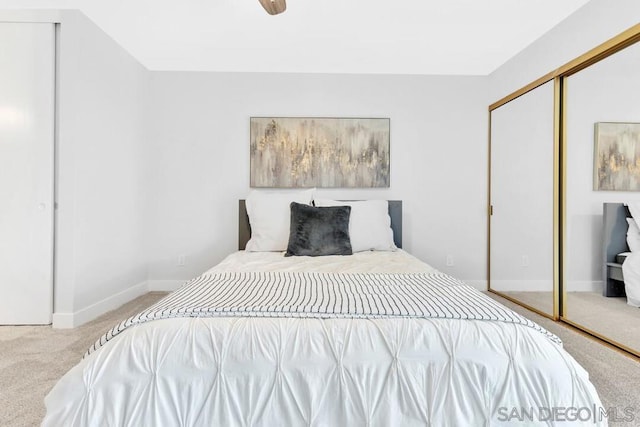 carpeted bedroom with ceiling fan and a closet