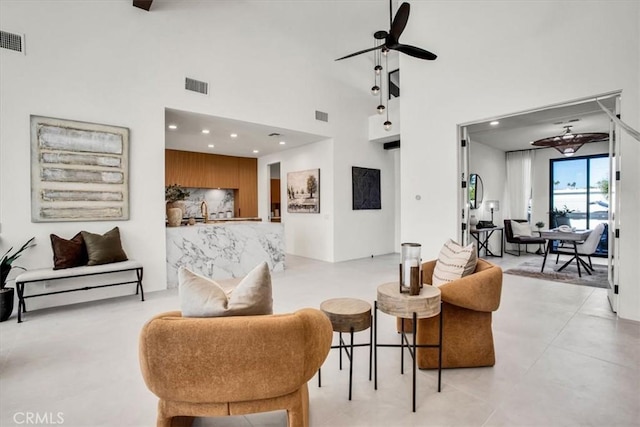 living room featuring ceiling fan and a towering ceiling