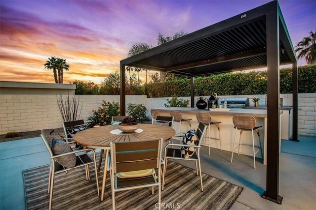 patio terrace at dusk featuring an outdoor bar