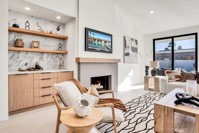 living room with lofted ceiling, a large fireplace, and sink