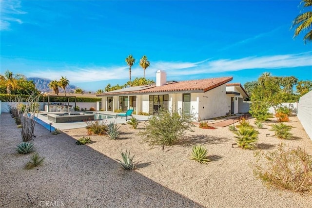 back of property featuring a fenced in pool and a patio