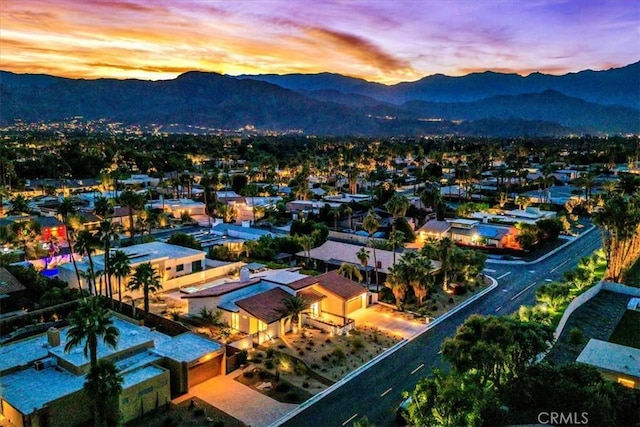 aerial view at dusk featuring a mountain view