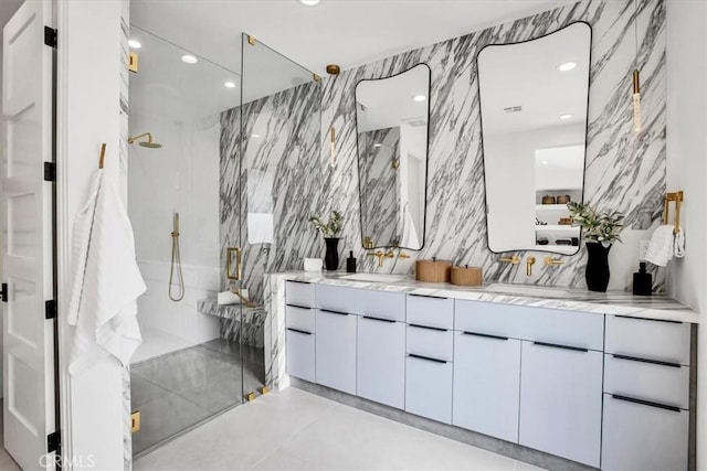 bathroom with vanity, a shower with door, and tile walls