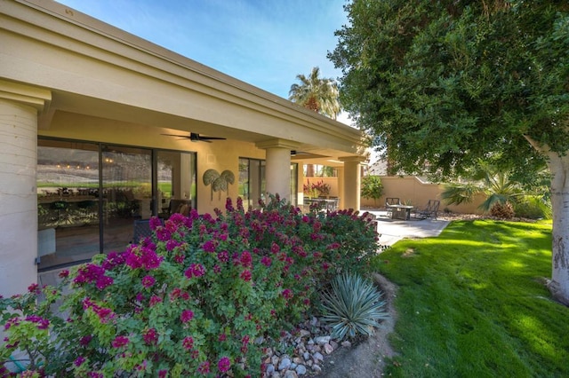 view of yard with ceiling fan and a patio