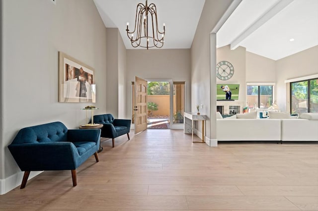 interior space featuring beam ceiling, high vaulted ceiling, light hardwood / wood-style floors, and an inviting chandelier