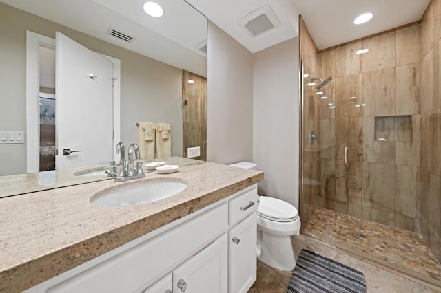 bathroom featuring tile patterned floors, vanity, toilet, and walk in shower