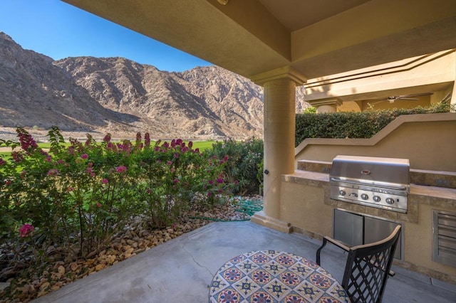 view of patio featuring a mountain view, grilling area, and an outdoor kitchen