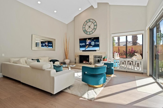 living room featuring high vaulted ceiling, beam ceiling, light wood-type flooring, and a high end fireplace