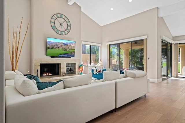 living room featuring beam ceiling, light hardwood / wood-style flooring, and high vaulted ceiling