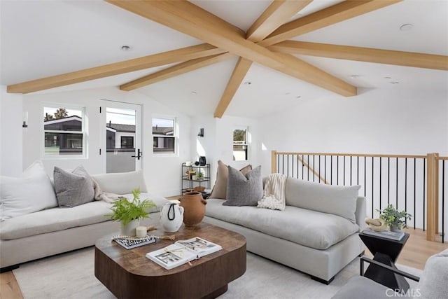 living room featuring vaulted ceiling with beams, light hardwood / wood-style flooring, and plenty of natural light