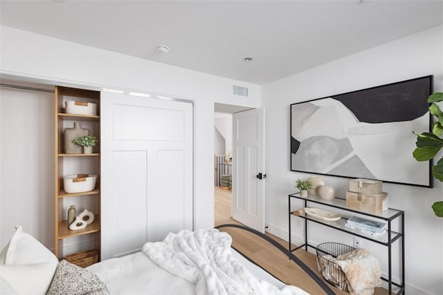 bedroom with wood-type flooring and a closet