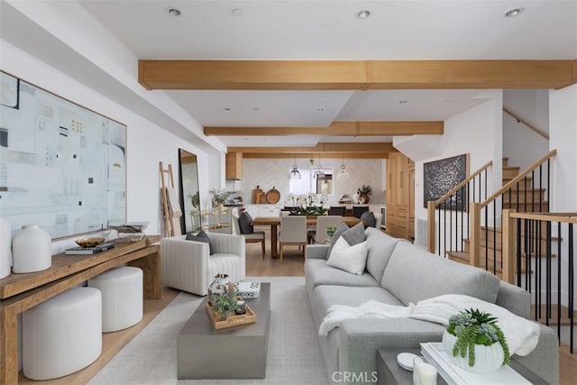 living room with beam ceiling and light wood-type flooring