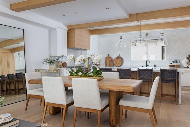 dining space with light wood-type flooring and sink