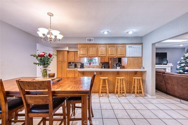 dining room featuring light tile patterned flooring and a chandelier