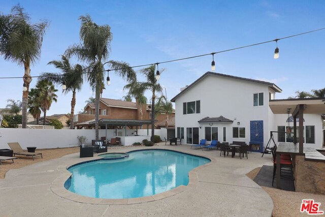 view of swimming pool featuring an in ground hot tub and a patio