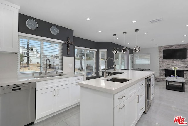 kitchen with a kitchen island with sink, white cabinetry, sink, and stainless steel dishwasher