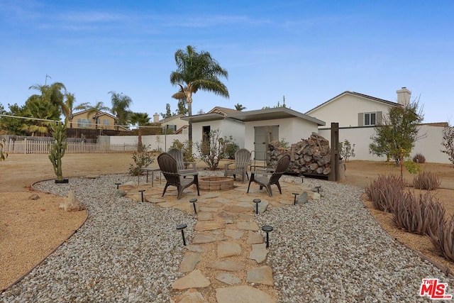 rear view of house with a patio and an outdoor fire pit