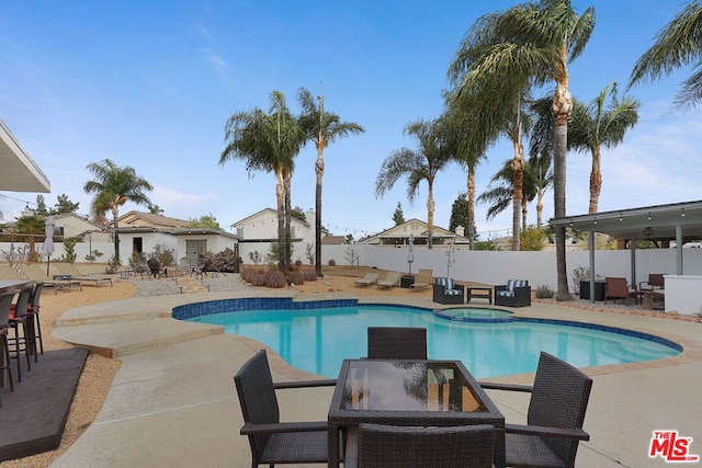 view of pool featuring an in ground hot tub and a patio