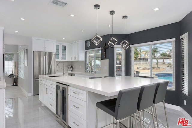 kitchen featuring white cabinets, plenty of natural light, and wine cooler