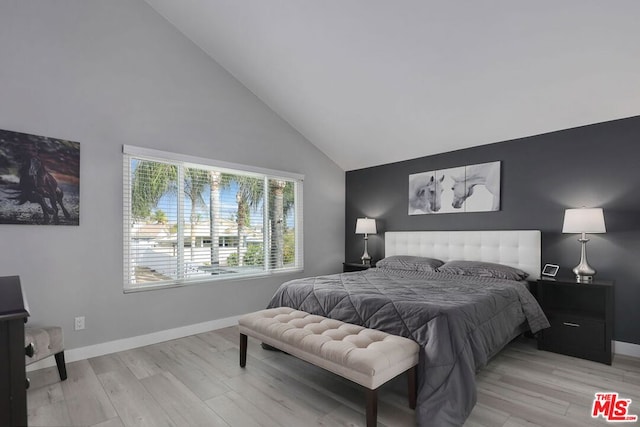 bedroom featuring light hardwood / wood-style floors and high vaulted ceiling