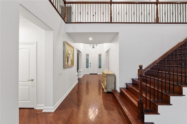 foyer with a towering ceiling and hardwood / wood-style flooring