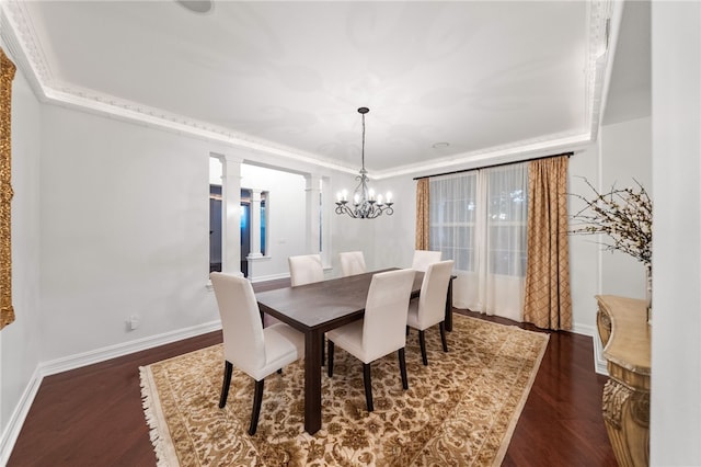 dining room with a chandelier, dark hardwood / wood-style flooring, crown molding, and decorative columns