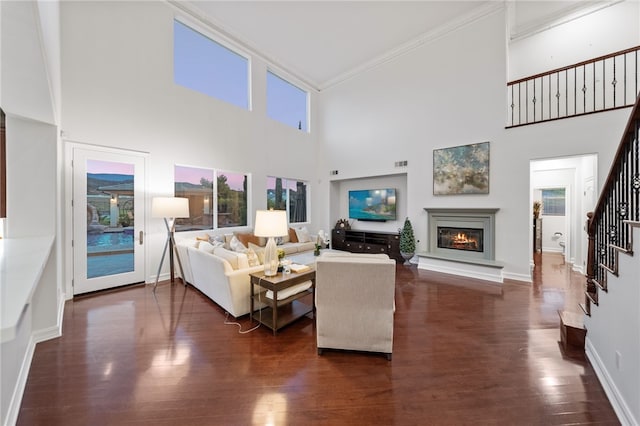 living room with a high ceiling, dark hardwood / wood-style floors, and crown molding