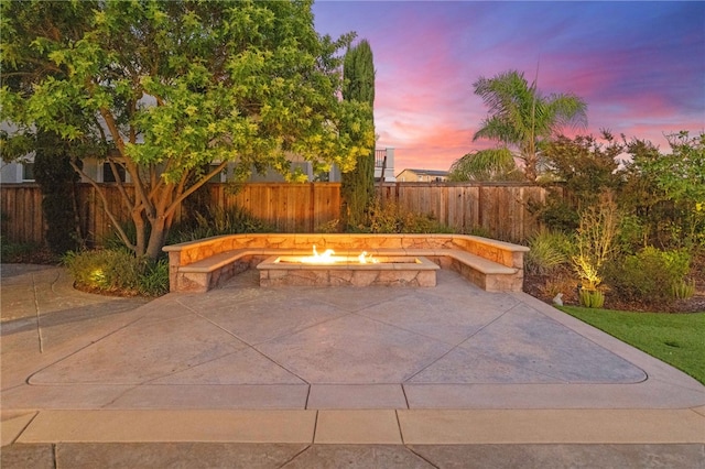 patio terrace at dusk featuring a fire pit