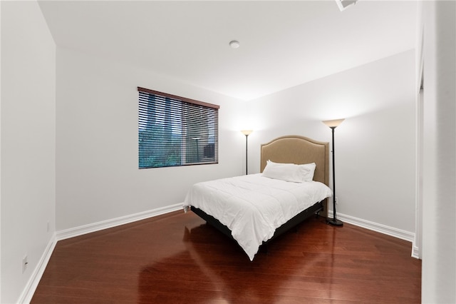 bedroom with dark hardwood / wood-style flooring