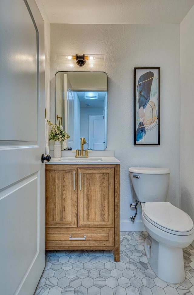 bathroom with tile patterned flooring, vanity, and toilet