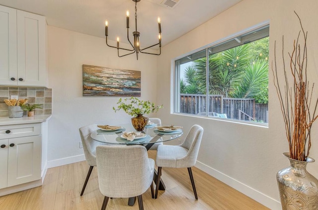 dining area with a chandelier and light wood-type flooring