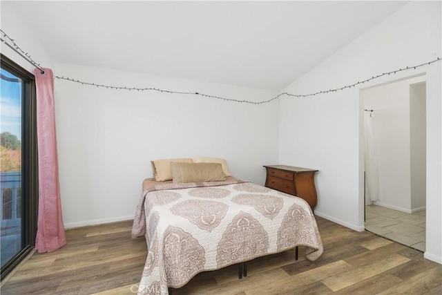 bedroom featuring hardwood / wood-style floors and lofted ceiling