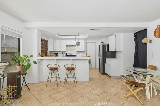 kitchen with a kitchen breakfast bar, white cabinetry, kitchen peninsula, and white stove