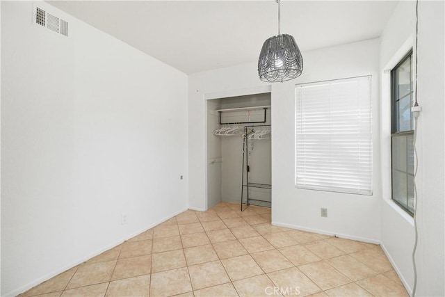 unfurnished bedroom featuring light tile patterned floors and a closet