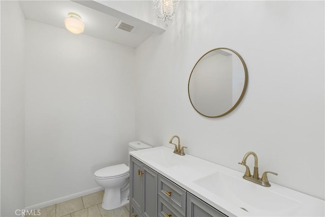 bathroom with tile patterned flooring, vanity, and toilet