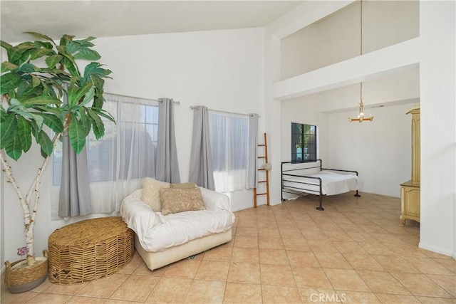 living area featuring a high ceiling, a wealth of natural light, a notable chandelier, and light tile patterned flooring