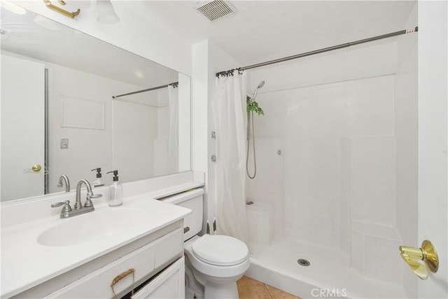 bathroom with tile patterned flooring, vanity, toilet, and walk in shower